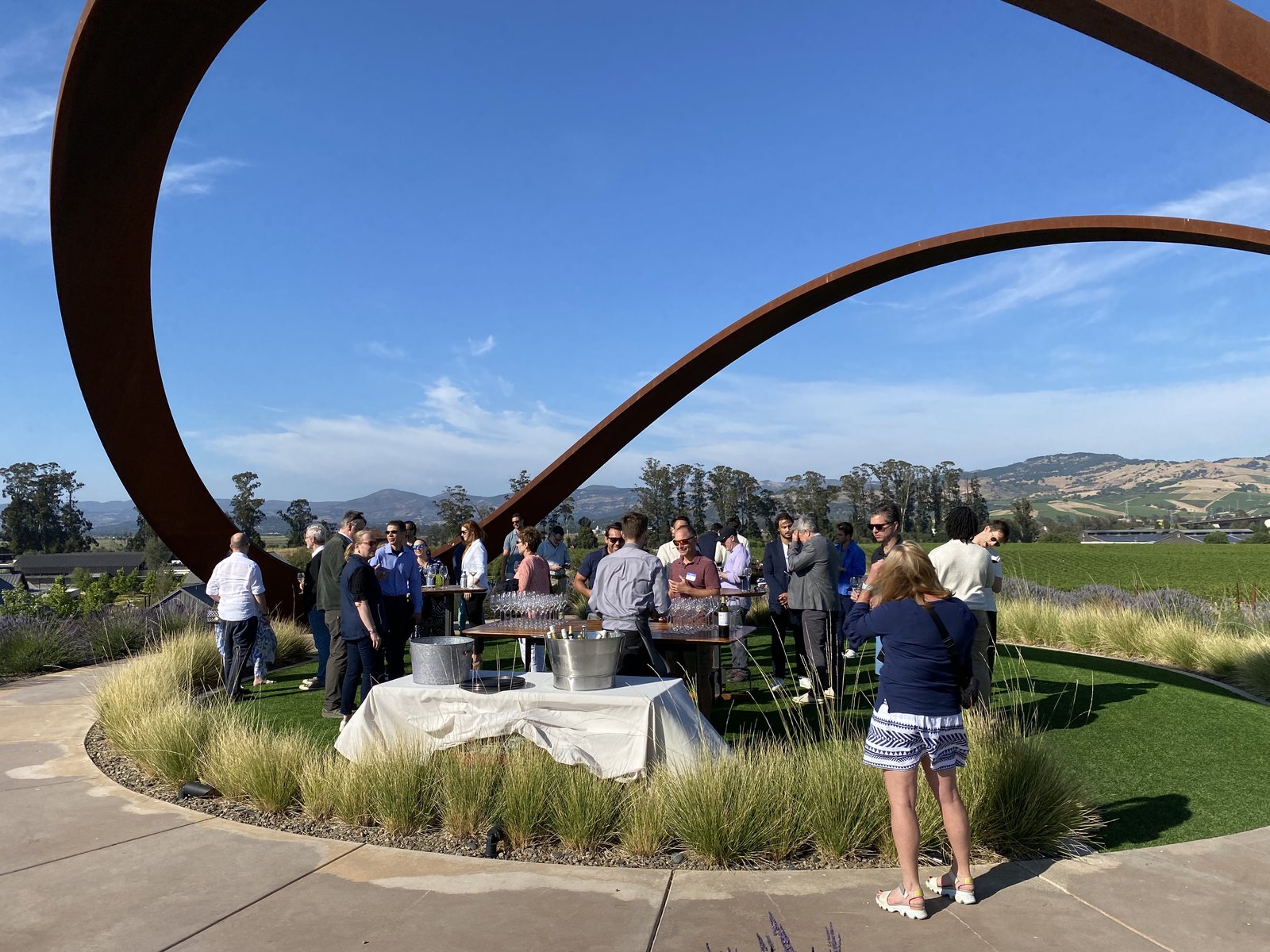 Founders mingling at the wine reception beneath the steel arches