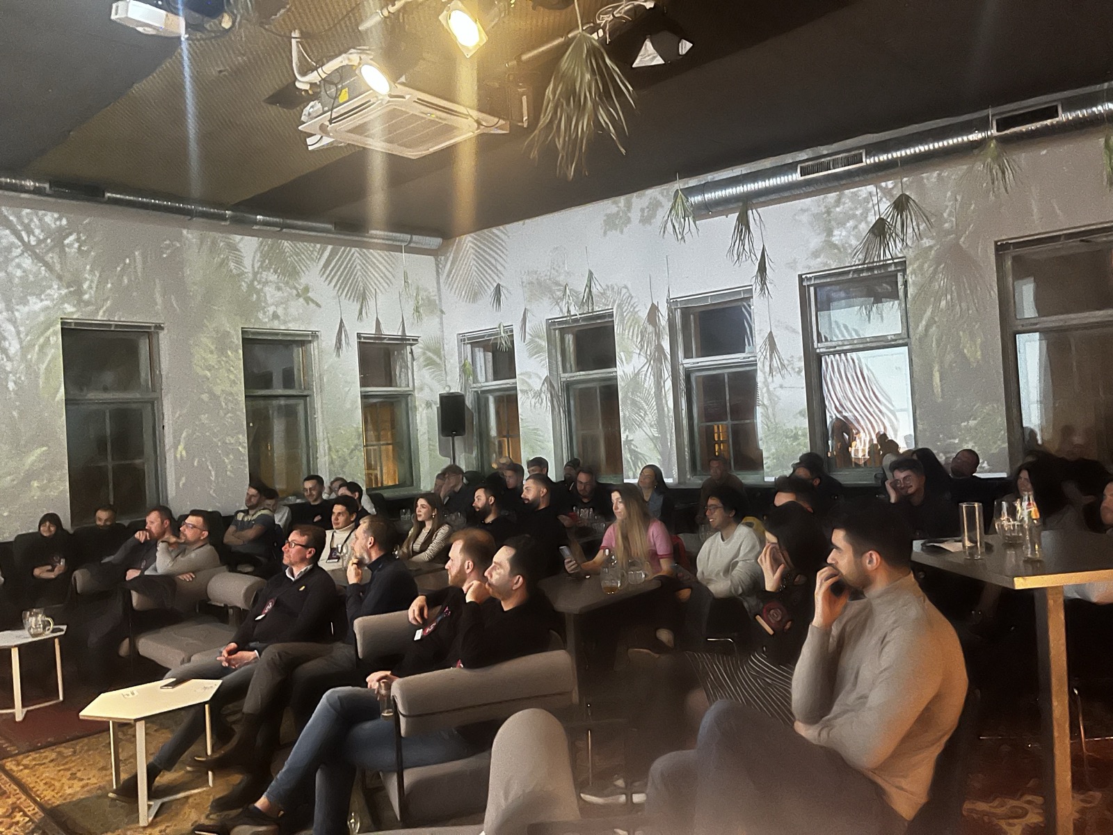 Founders seated for an evening talk under botanical projections
